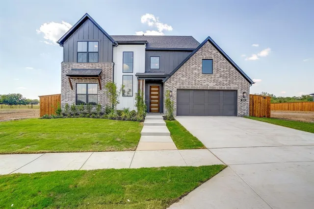 a front view of a house with a yard and trees