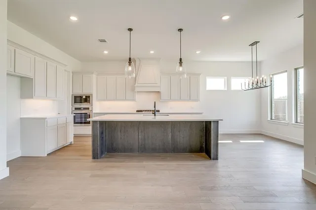 a kitchen with kitchen island a sink stainless steel appliances and cabinets