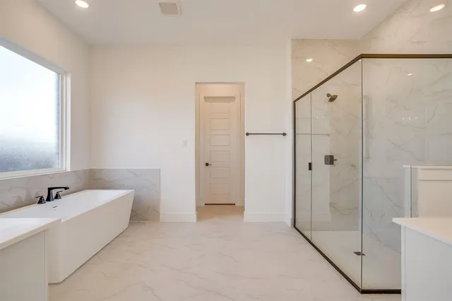 a spacious bathroom with a shower and a tub