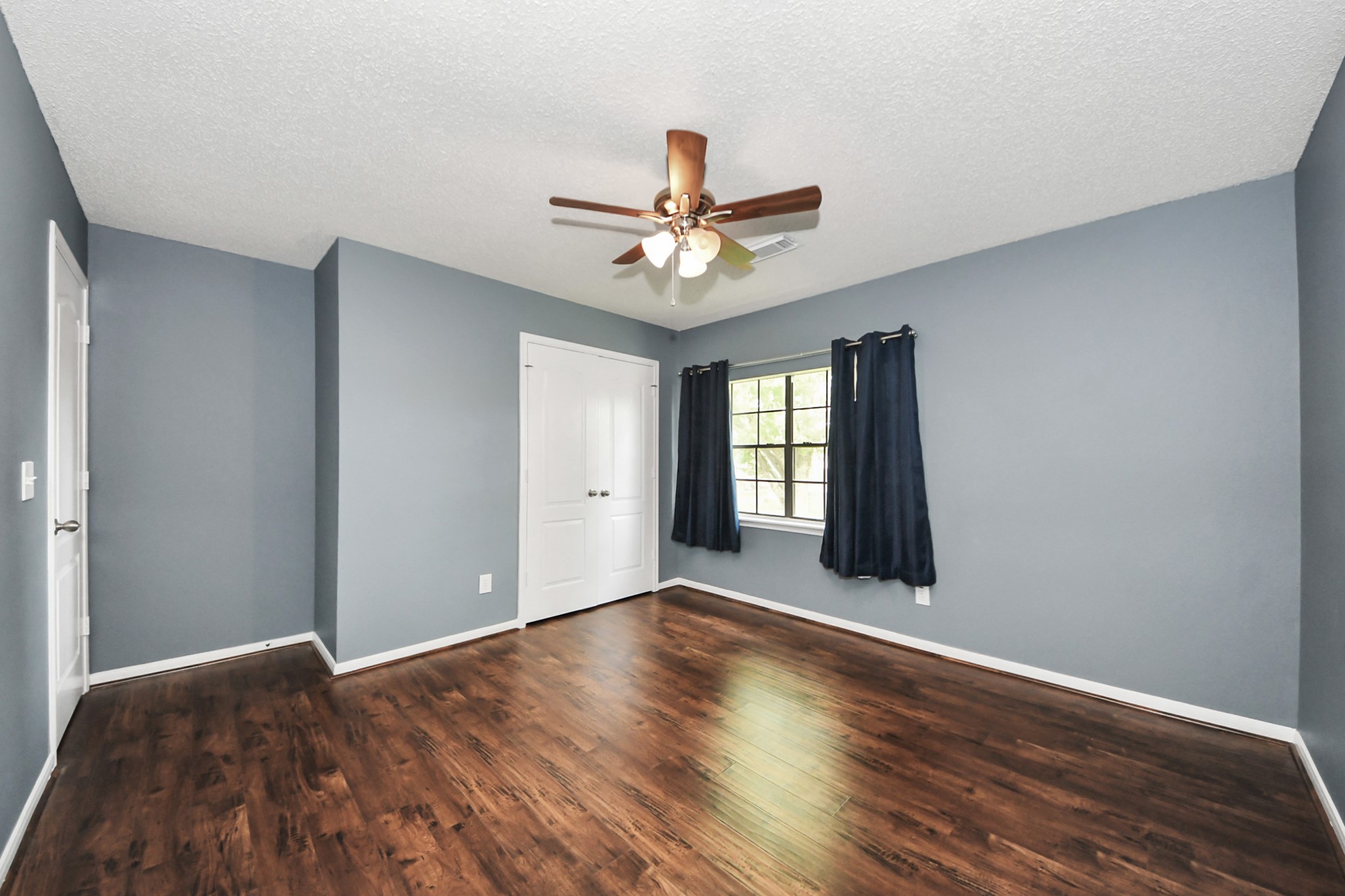 3107 Dulaney Road Houston, TX 77084 - Photo 32 of 50 a view of an empty room with window and wooden floor