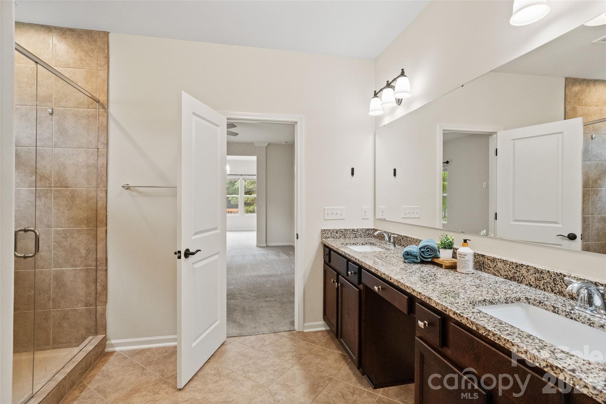 5299 Admirals Landing Lancaster, SC 29720 - Photo 14 of 39 a spacious bathroom with a granite countertop sink a mirror and a shower