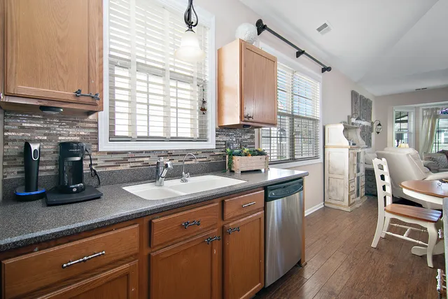 a kitchen with granite countertop a sink appliances cabinets and dining table chair