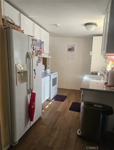 a kitchen with stainless steel appliances kitchen island granite countertop a refrigerator and a sink