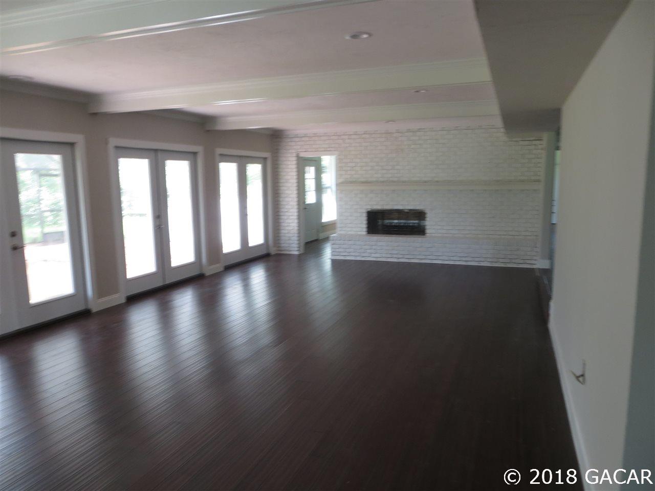 3510 Southwest 63rd Lane Gainesville, FL 32608 - Photo 7 of 13 Huge family room overlooks back yard & golf course. Master Bedroom lies beyond the brick wall & shares two way fireplace.