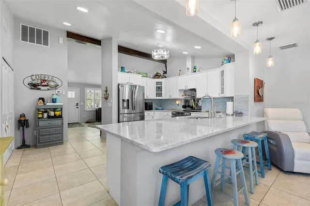 a kitchen with stainless steel appliances granite countertop a refrigerator sink and stove