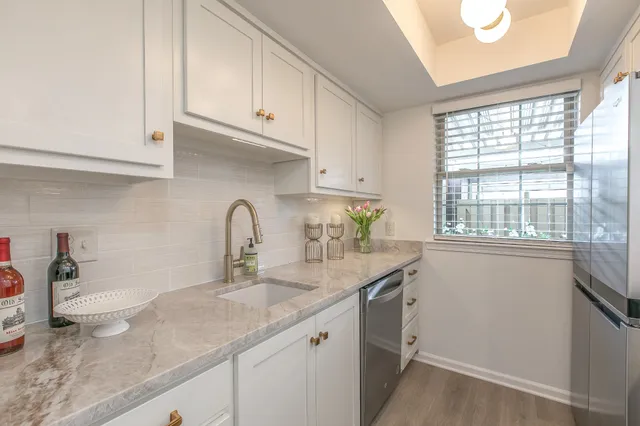a kitchen with granite countertop white cabinets and a window