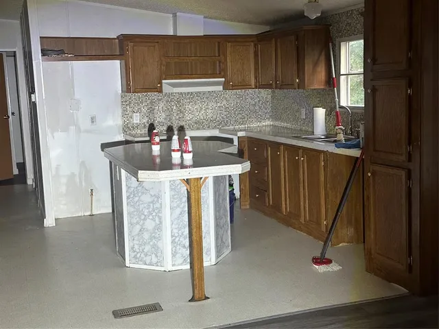 a kitchen with stainless steel appliances granite countertop a sink stove and cabinets