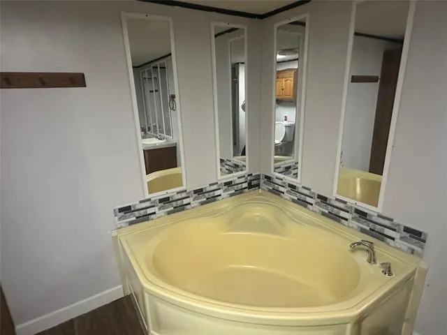 a bathroom with a tub and mirror