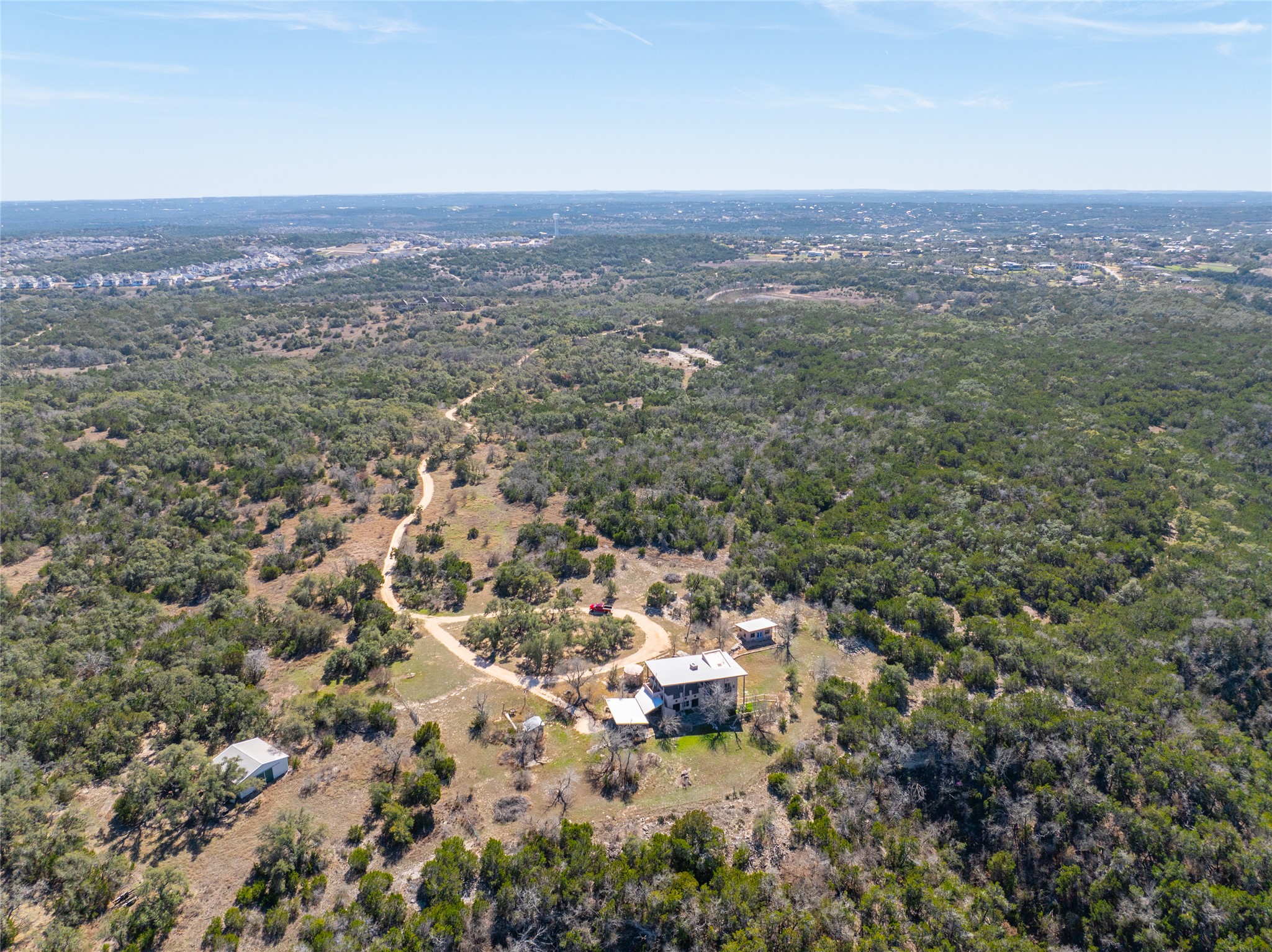 17318 Hamilton Pool Road Austin, TX 78738 - Photo 3 of 21 A winding gravel driveway leads up to this secluded hilltop retreat surrounded by dense woodlands.