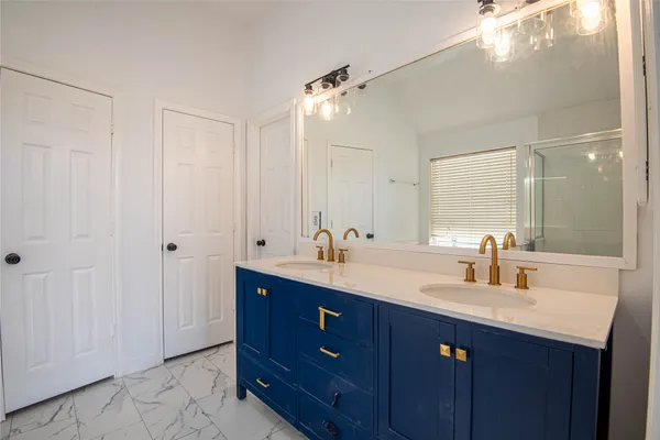 a bathroom with double vanity sinks and a mirror