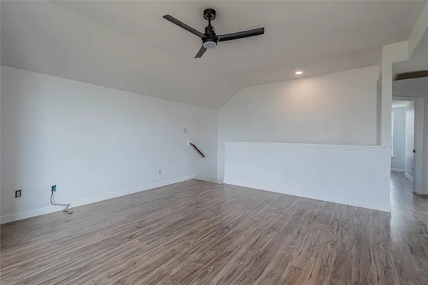 a view of a room with wooden floor and a ceiling fan