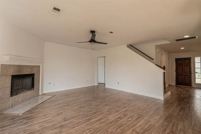 a view of a livingroom with wooden floor and a fireplace
