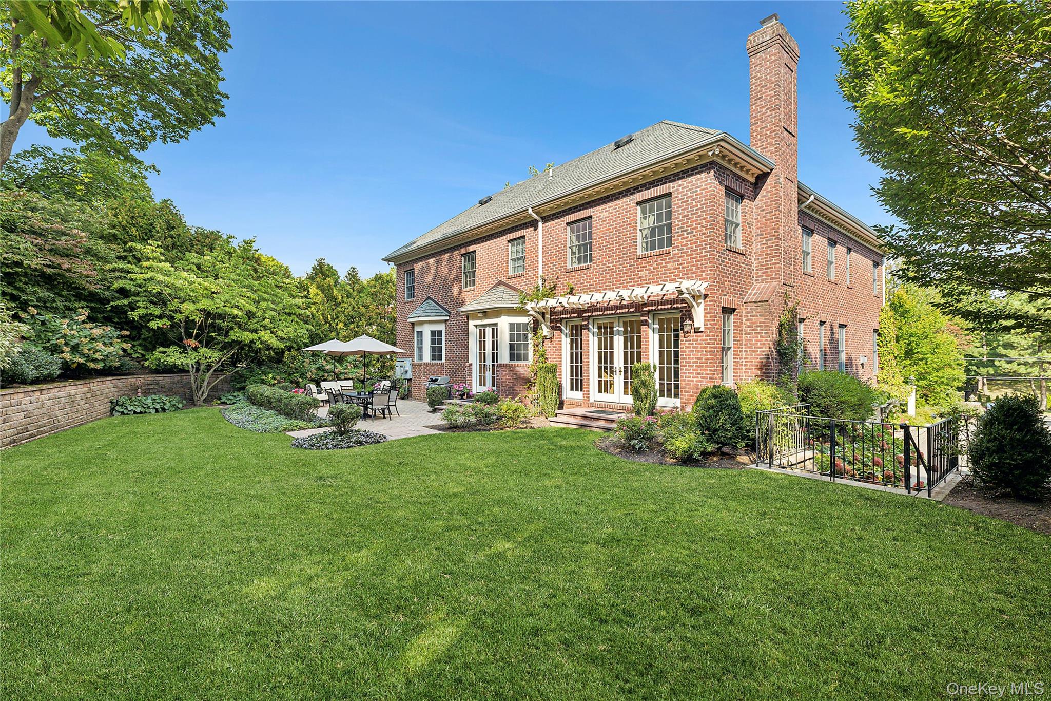 1270 Plandome Road Manhasset, NY 11030 - Photo 20 of 23 a view of a house with backyard sitting area and garden