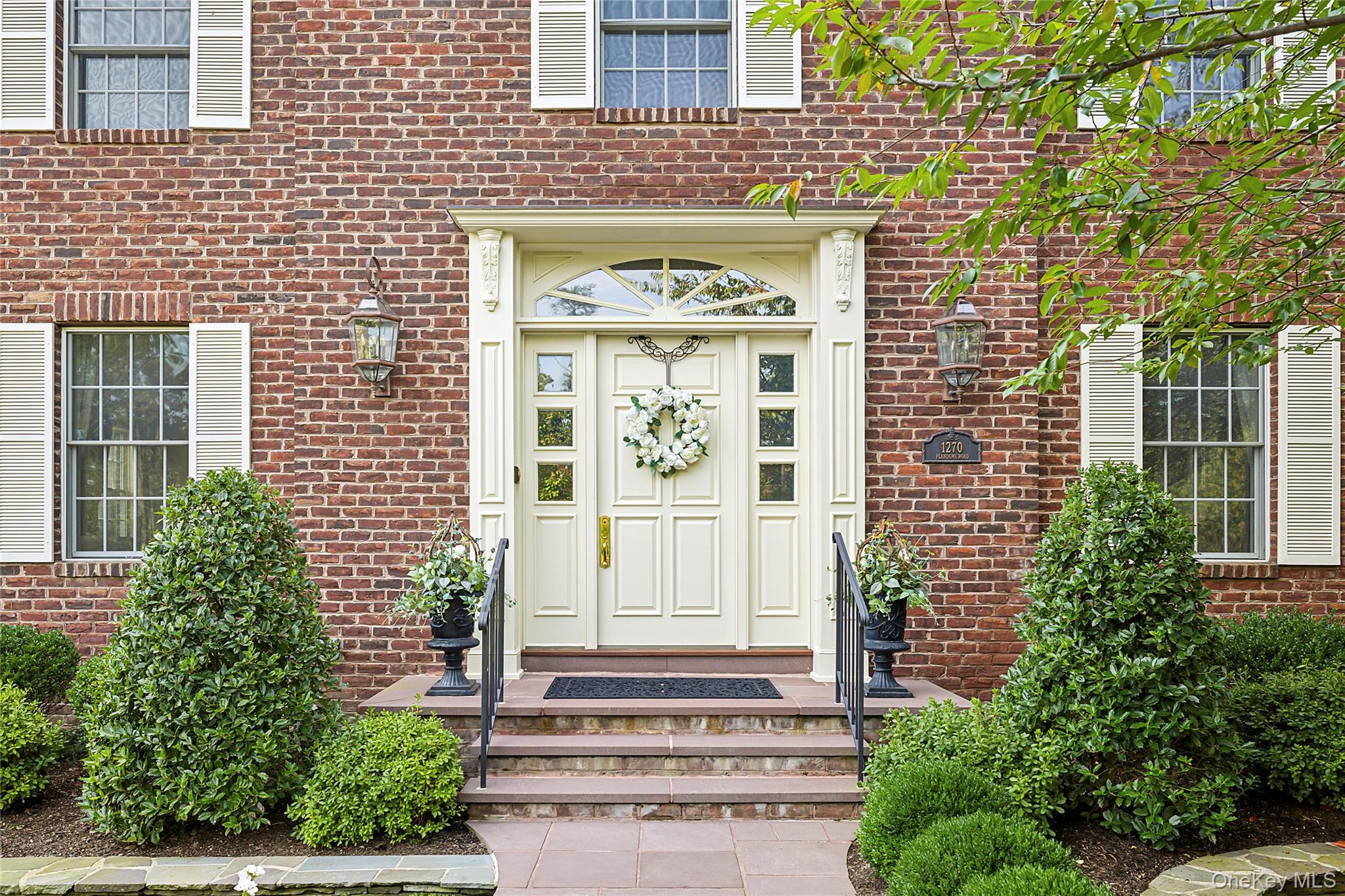 1270 Plandome Road Manhasset, NY 11030 - Photo 2 of 23 a front view of a house with a garden