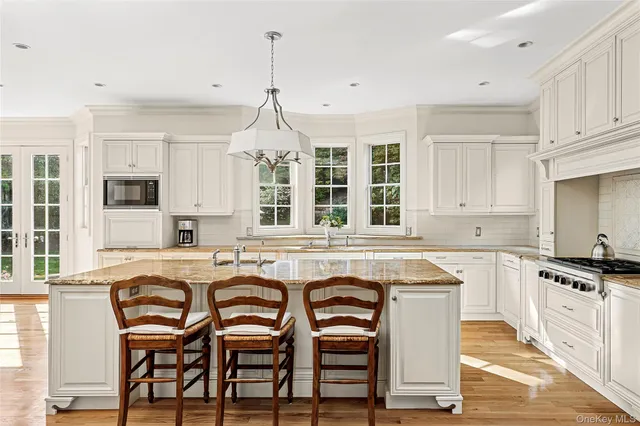 a kitchen with granite countertop white cabinets and chairs