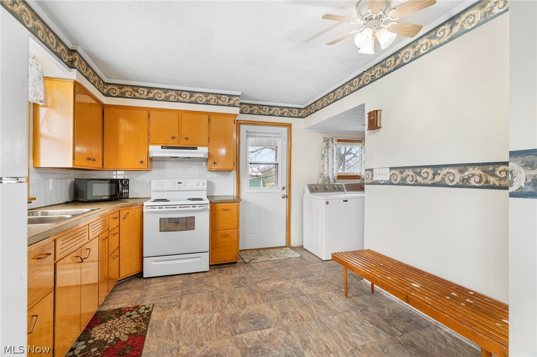 1640 Old Delaware Road Mount Vernon, OH 43050 - Photo 15 of 49 Kitchen with white appliances, washing machine and dryer, a ceiling fan, light countertops, and stone finish floors