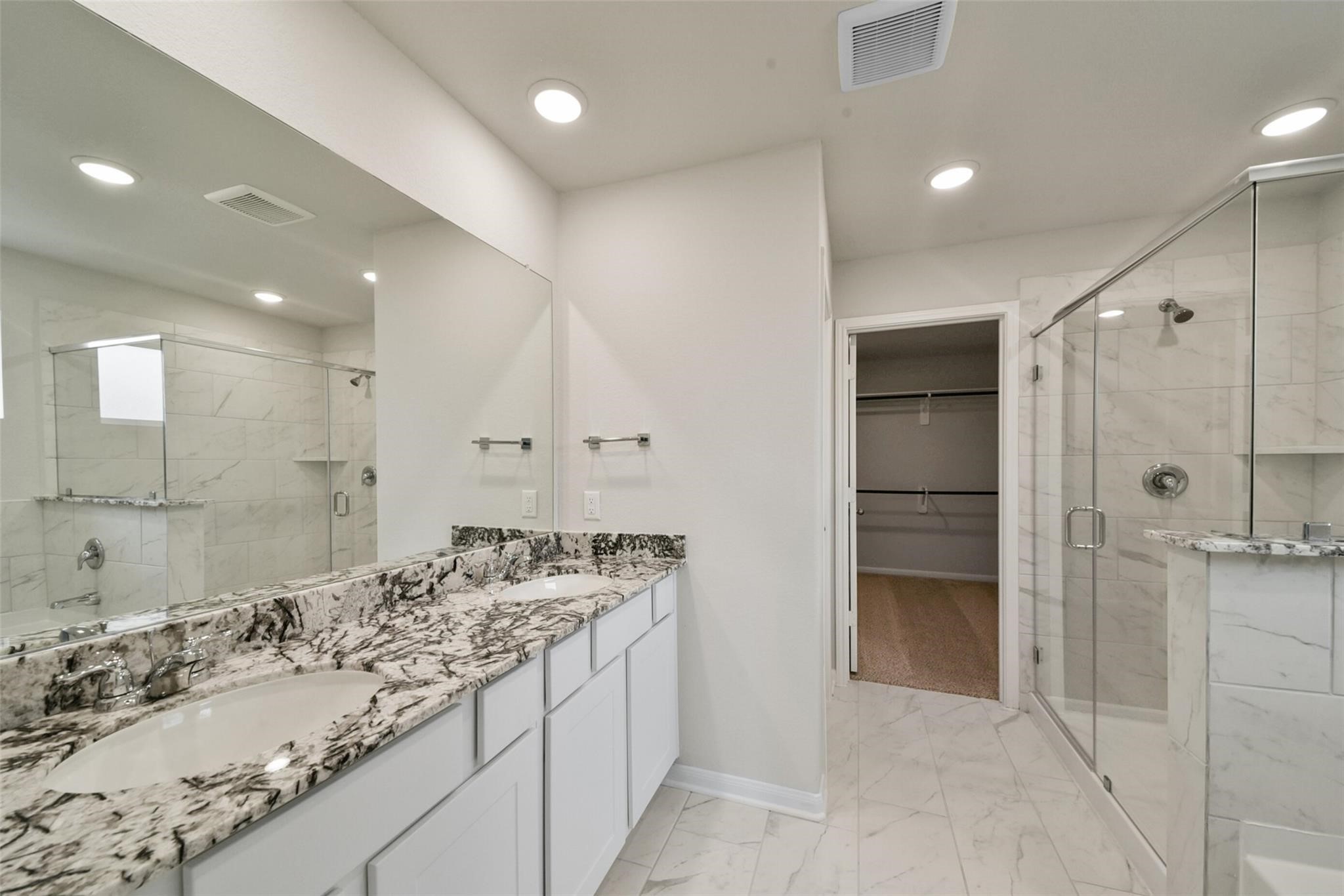 10522 Plumas Run Drive Rosharon, TX 77583 - Photo 18 of 29 Sophisticated en-suite featuring a double granite vanity, glass-enclosed marble-tile shower, and a spacious walk-in closet.