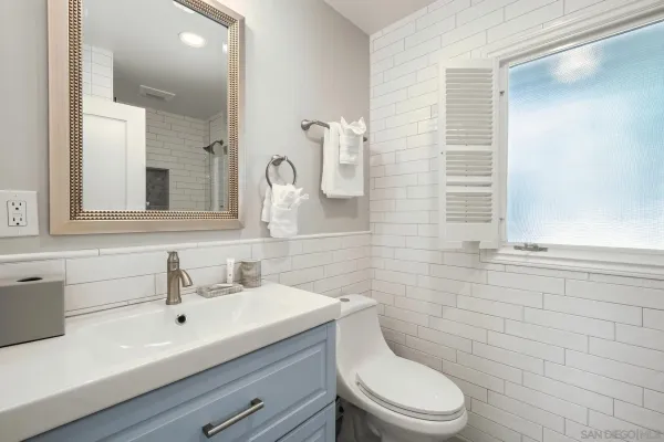 a bathroom with a granite countertop sink mirror vanity and toilet
