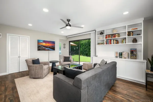 a view of a patio with couches table and chairs under an umbrella