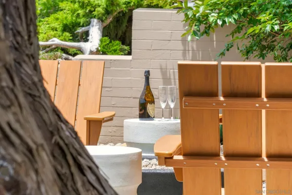 a view of a patio with couches table and chairs under an umbrella