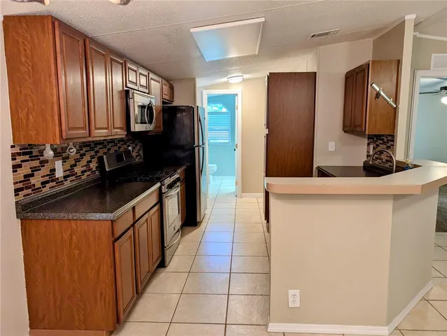 a kitchen with stainless steel appliances a sink and a refrigerator