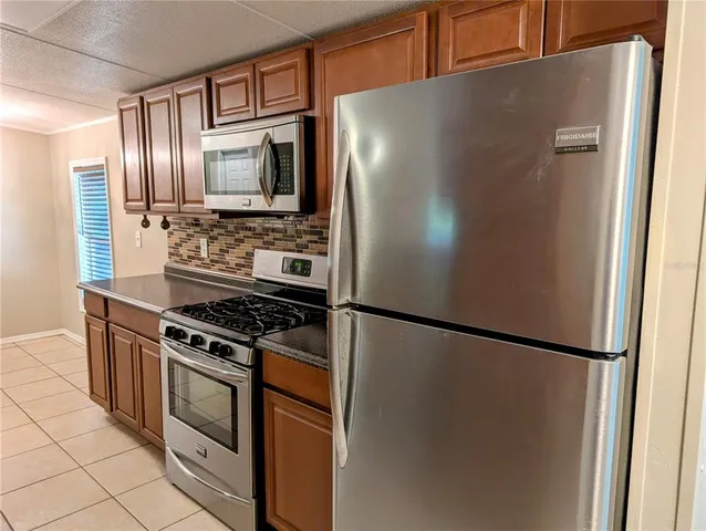 a kitchen with stainless steel appliances granite countertop a refrigerator and a stove