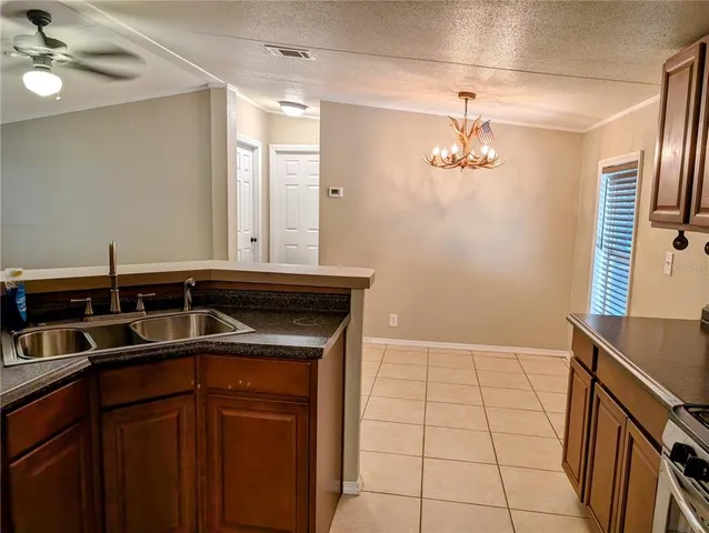 a kitchen with a sink a stove cabinets and utility
