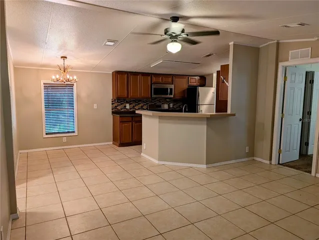 a kitchen with stainless steel appliances kitchen island granite countertop a refrigerator and a stove top oven