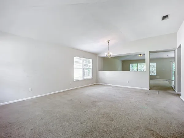 an empty room with window and bathroom