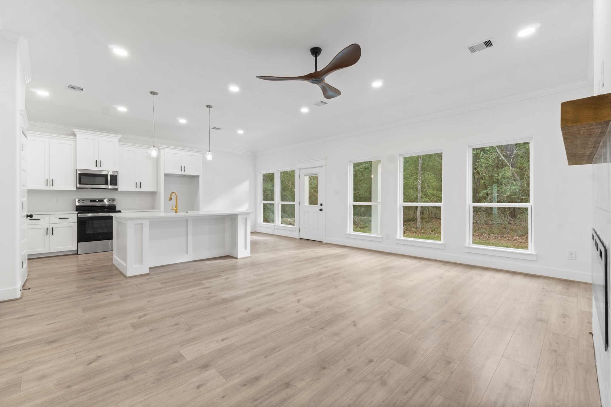 241 Clear Springs Trinity, TX 75862 - Photo 17 of 46 a view of an empty room with wooden floor and a kitchen