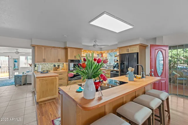 a dining room with furniture a potted plant and a kitchen view