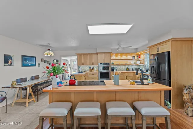 a dining room with furniture a chandelier and kitchen view