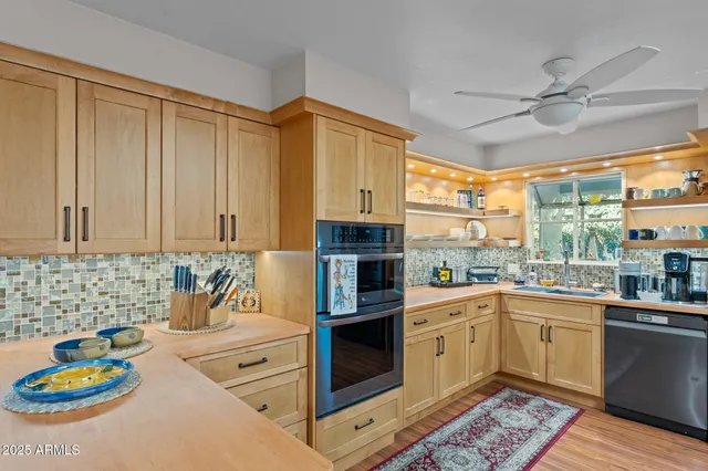 a kitchen with stainless steel appliances a stove a sink and cabinets