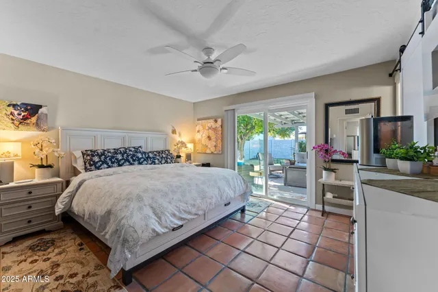 a bedroom with a bed table and chairs