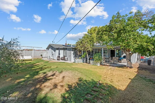 a view of a house with backyard and sitting area