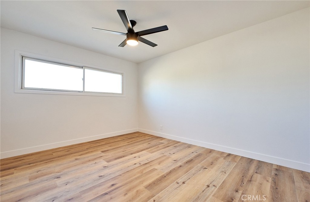 9871 Magnolia Street Bloomington, CA 92316 - Photo 12 of 16 an empty room with wooden floor fan and windows