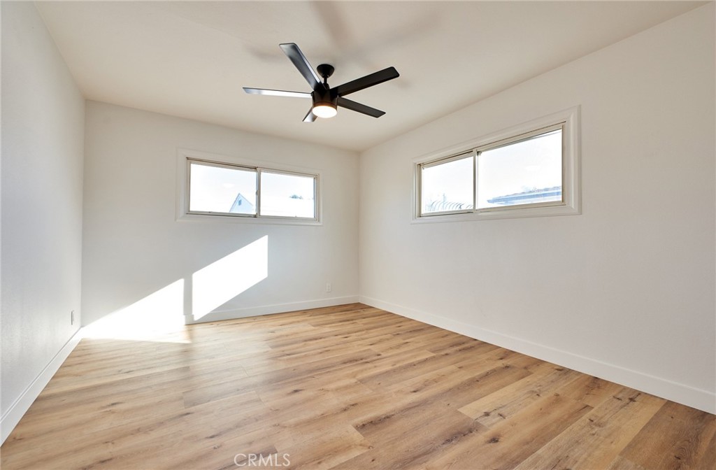 9871 Magnolia Street Bloomington, CA 92316 - Photo 13 of 16 a view of empty room with wooden floor and fan