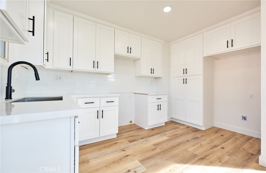 9871 Magnolia Street Bloomington, CA 92316 - Photo 4 of 16 a kitchen with stainless steel appliances granite countertop a refrigerator sink and white cabinets