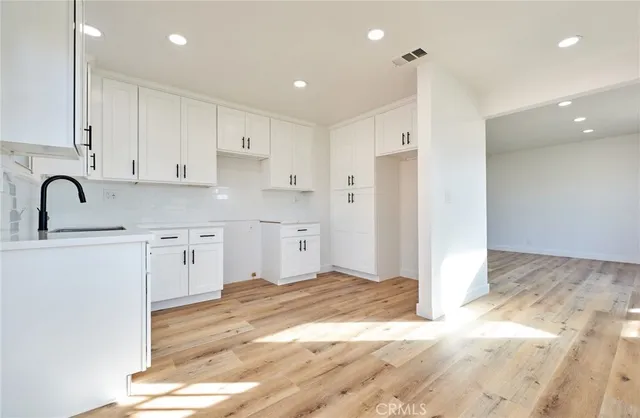 a kitchen with stainless steel appliances granite countertop a refrigerator sink and white cabinets