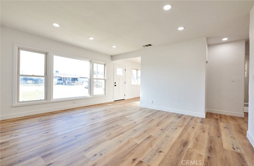 9871 Magnolia Street Bloomington, CA 92316 - Photo 7 of 16 a view of an empty room with wooden floor and a window