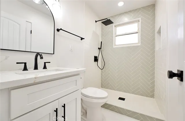 a bathroom with a sink a toilet and shower