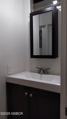 a bathroom with a sink vanity and a mirror