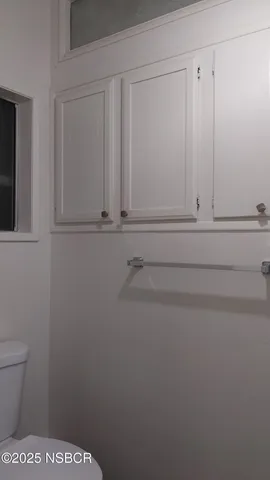 a bathroom with a toilet and dryer