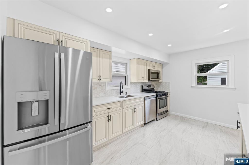 18 Farmingdale Avenue Bloomfield, NJ 07003 - Photo 12 of 50 a kitchen with stainless steel appliances a refrigerator sink and microwave