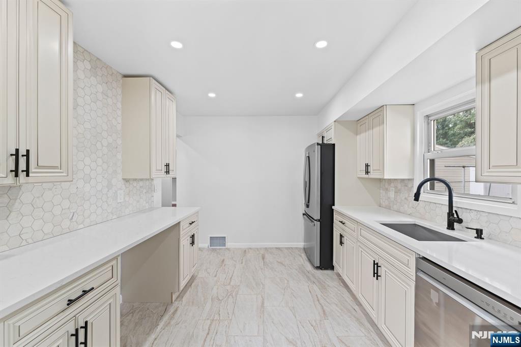 18 Farmingdale Avenue Bloomfield, NJ 07003 - Photo 15 of 50 a large white kitchen with a sink stainless steel appliances and cabinets