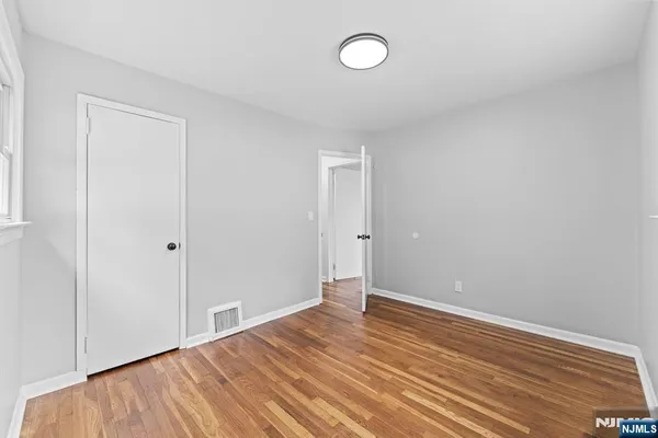 a view of a room with wooden floor and white walls