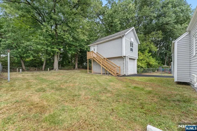 a view of a house with backyard and tree