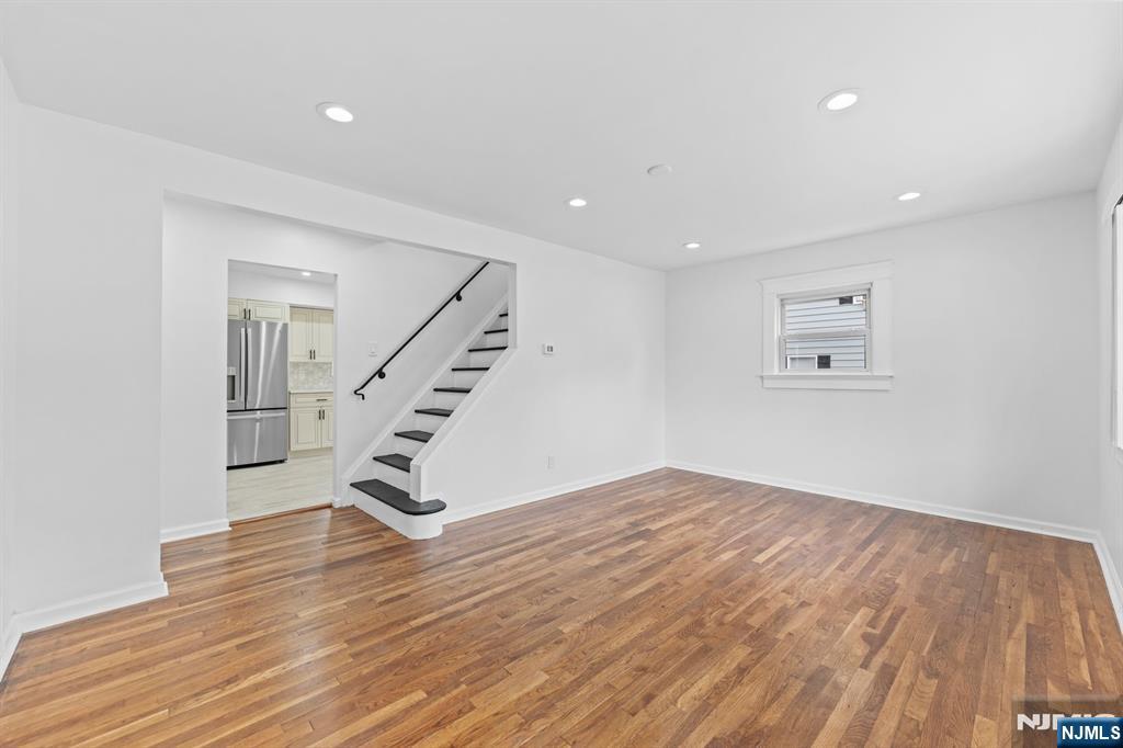 18 Farmingdale Avenue Bloomfield, NJ 07003 - Photo 10 of 50 a view of an empty room with wooden floor and stairs