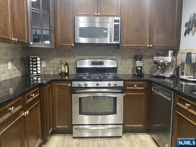 54 Polifly Road, Unit 104 Hackensack, NJ 07601 - Photo 2 of 11 a kitchen with granite countertop a stove top oven cabinetry a sink and a refrigerator