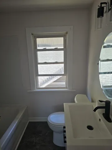 a bathroom with a sink toilet and a window